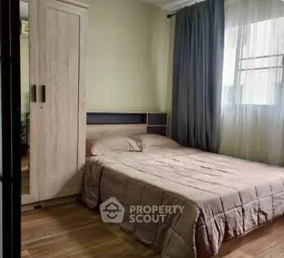 Cozy bedroom with modern wardrobe and natural light through large window.