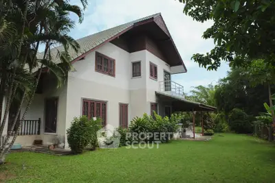 Charming two-story house with lush garden and balcony, perfect for serene living.