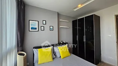Modern bedroom with stylish decor and ample natural light, featuring a sleek wardrobe and cozy bed with vibrant pillows.
