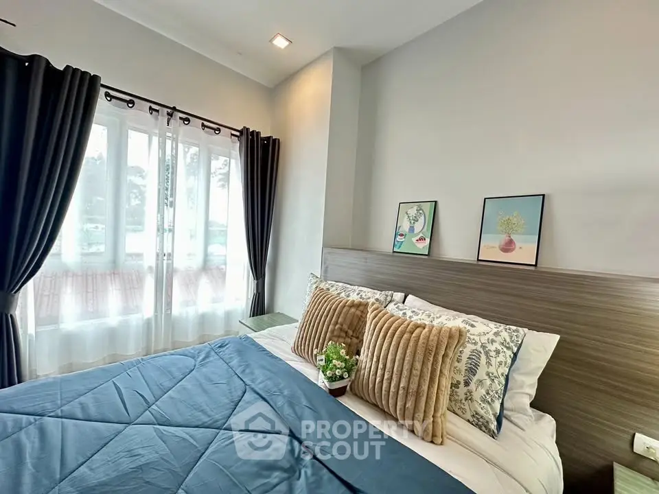 Cozy bedroom with stylish decor and large window for natural light