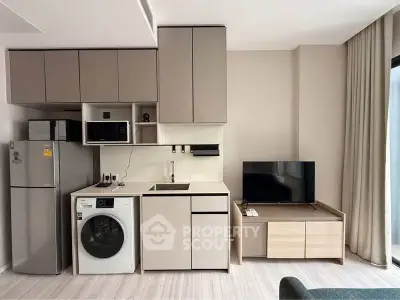 Modern compact kitchen with integrated appliances and sleek cabinetry in a stylish apartment.