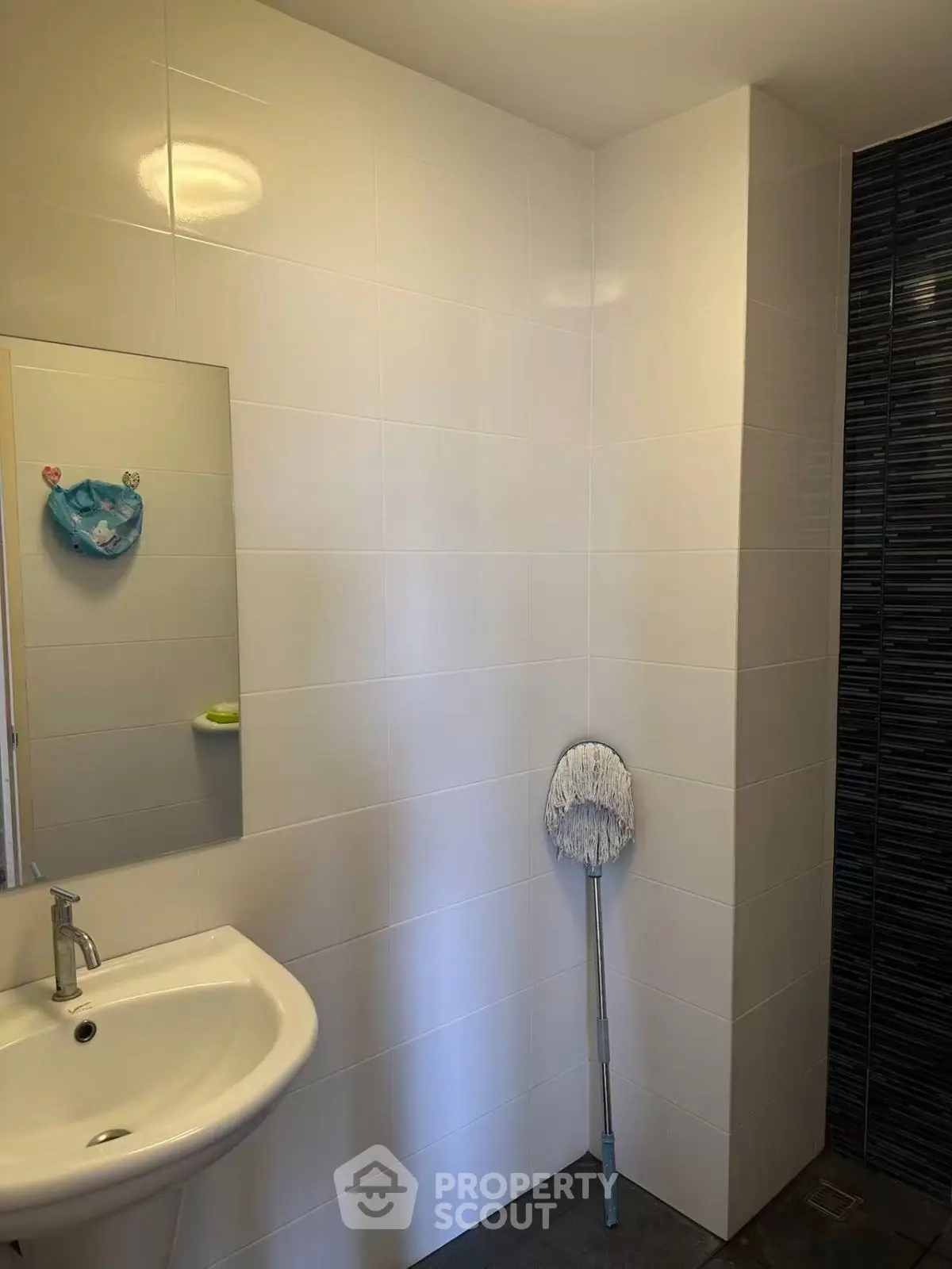 Modern bathroom with sleek white tiles and a stylish sink, perfect for contemporary living.
