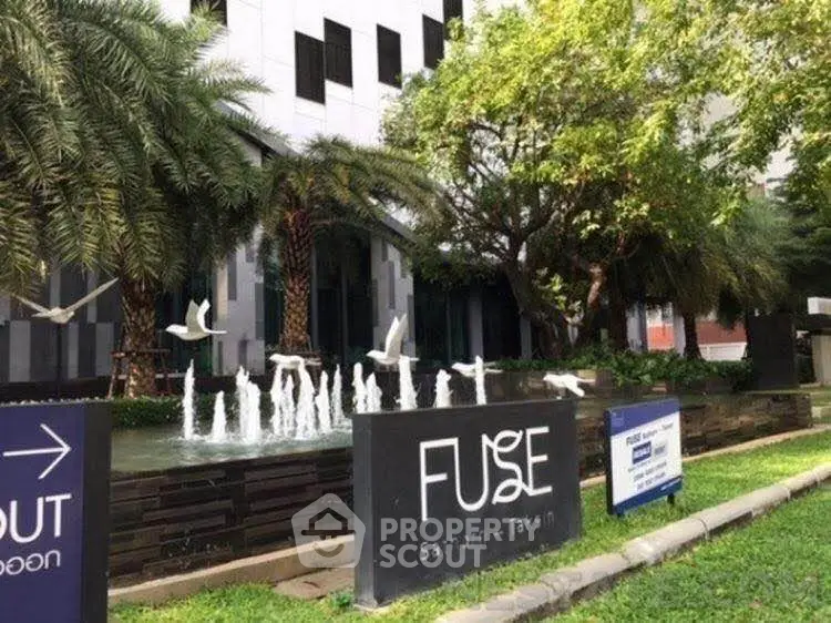 Modern building exterior with lush greenery and water fountain at Fuse Sathorn-Taksin.