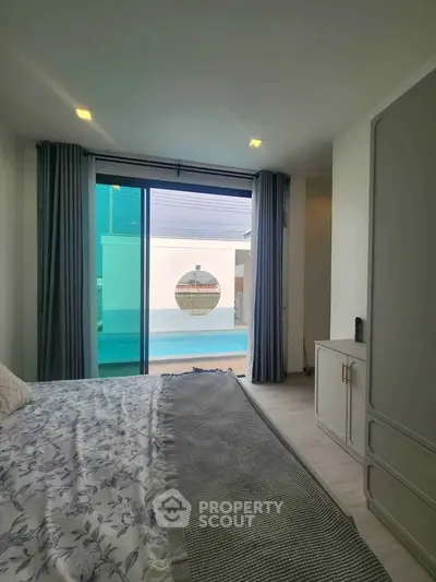 Spacious bedroom with pool view and modern decor in luxury home