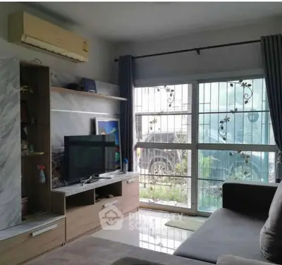 Cozy living room with modern decor, large window, and air conditioning unit.