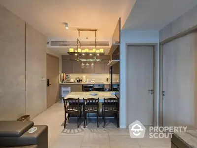 Modern kitchen with dining area featuring elegant lighting and contemporary design.