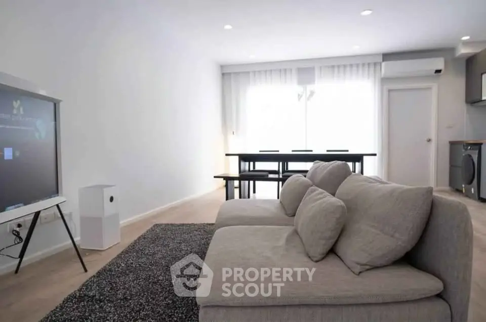 Spacious modern living room with cozy sofa and dining area, perfect for relaxation and entertaining.