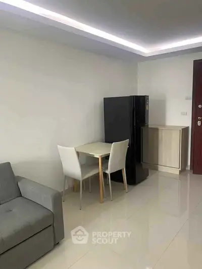 Modern apartment interior with sleek furniture and glossy flooring, featuring a compact dining area and stylish sofa.