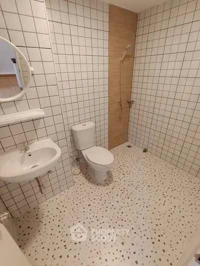 Modern minimalist bathroom with white tiles and terrazzo flooring