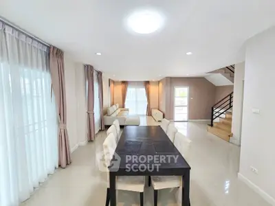 Spacious modern living room with dining area and elegant staircase