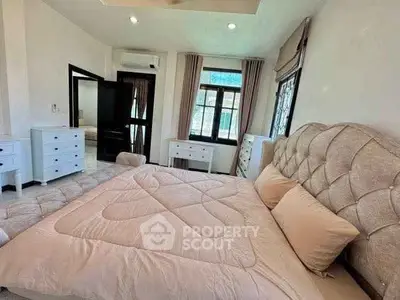Spacious bedroom with elegant decor and ample natural light