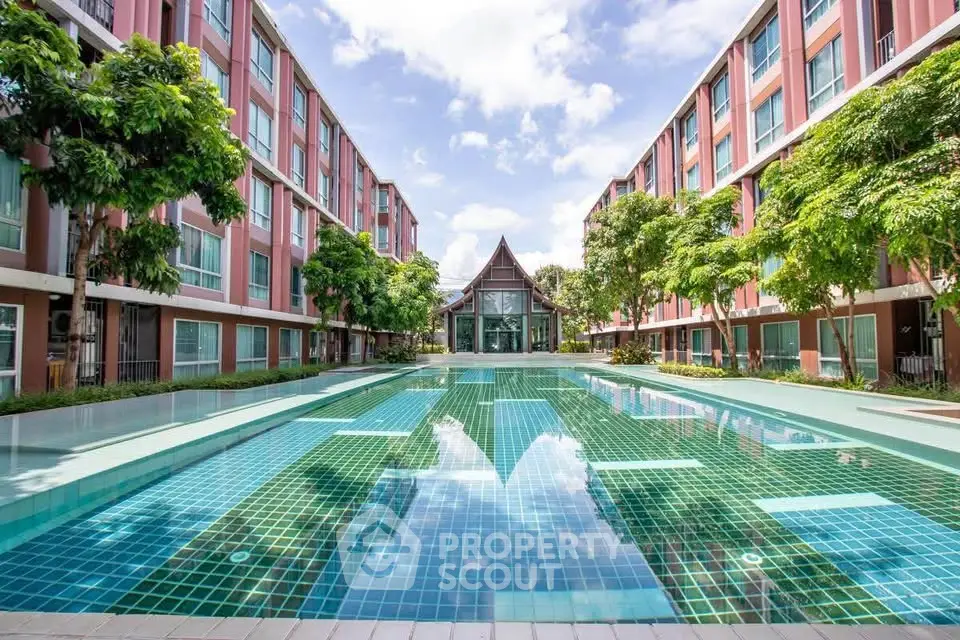 Stunning residential complex with a large outdoor pool and lush greenery.
