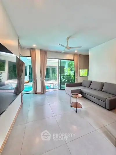 Spacious living room with pool view and modern furnishings