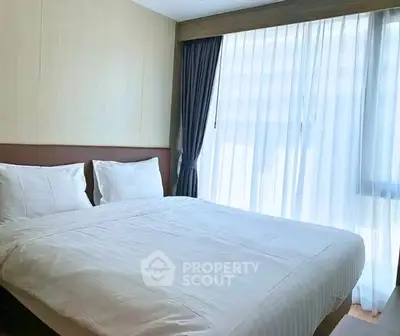 Cozy bedroom with large window and elegant curtains in modern apartment