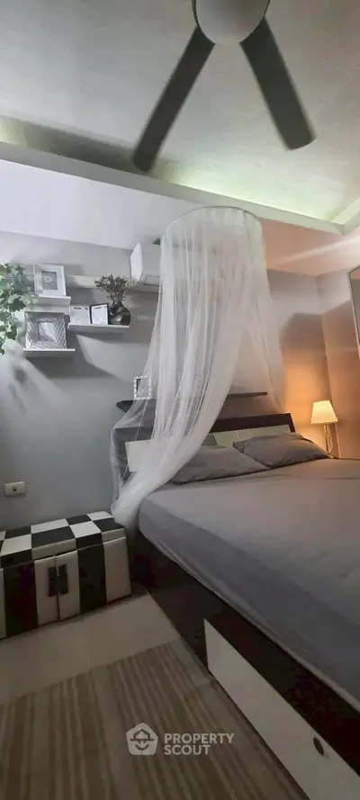 Cozy bedroom with modern decor and ceiling fan, perfect for relaxation.