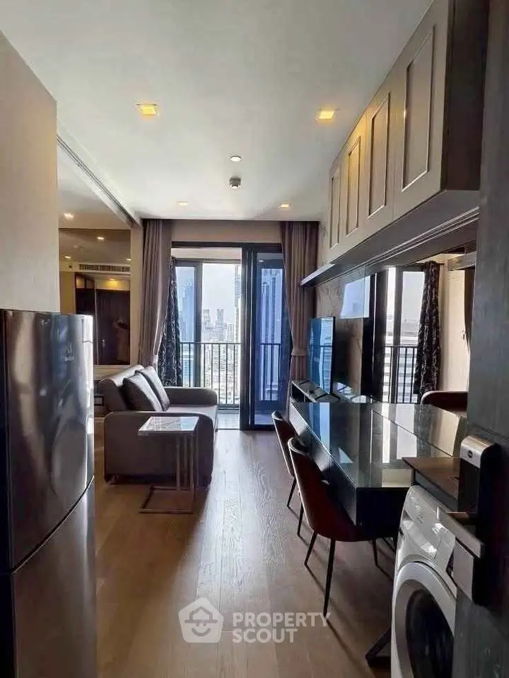 Modern apartment interior with open kitchen and living room, featuring city view from balcony.