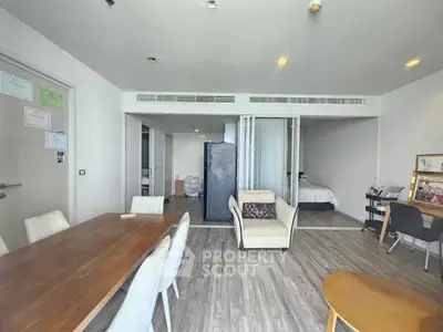 Modern open-plan living room with dining area and bedroom view