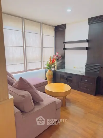 Charming living room with cozy sofa, elegant wooden furniture, and large windows for natural light.