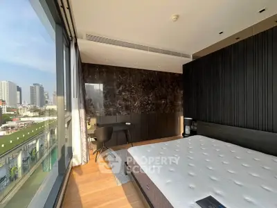 Luxurious bedroom with city view and modern decor, featuring floor-to-ceiling windows and sleek furnishings.
