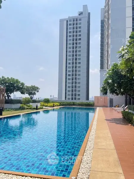 Luxurious high-rise building with stunning outdoor pool and lush greenery.