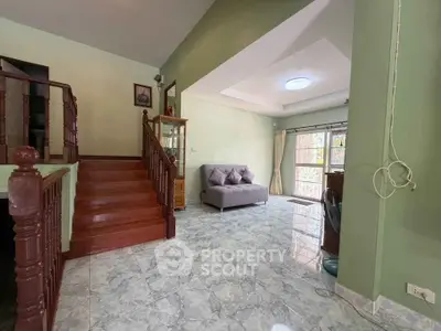Spacious living room with staircase and natural light in a modern home