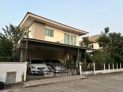Charming two-story house with spacious carport and lush greenery in a serene neighborhood.