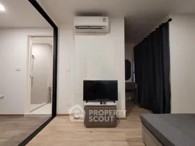 Modern living room with air conditioning and TV, featuring sleek design and cozy ambiance.