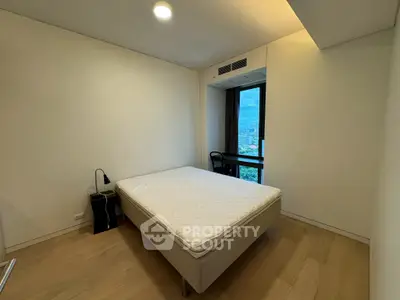 Modern minimalist bedroom with city view and natural light