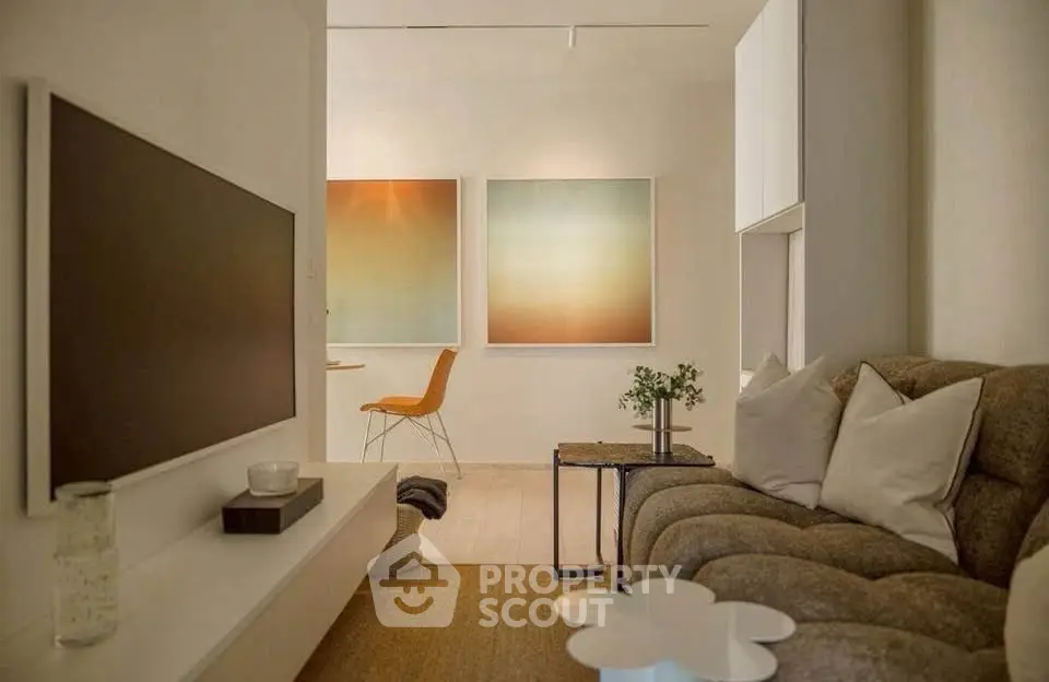 Stylish modern living room with cozy sofa and wall-mounted TV, perfect for relaxation.