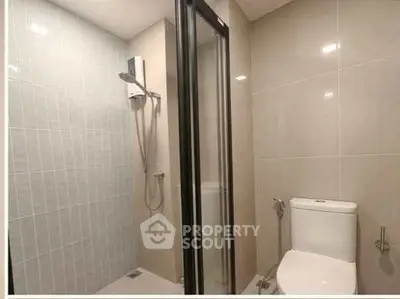 Modern bathroom with sleek shower and toilet in contemporary design.