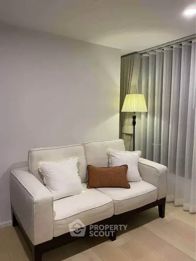 Cozy living room with elegant sofa and floor lamp, perfect for relaxation.