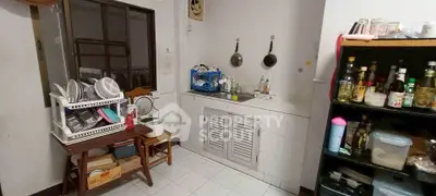 Cozy kitchen with ample storage and countertop space, featuring a dish rack and a variety of kitchen essentials.