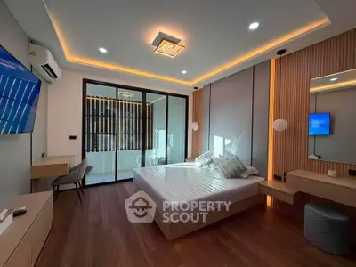 Modern bedroom with stylish lighting and large glass doors leading to a balcony.