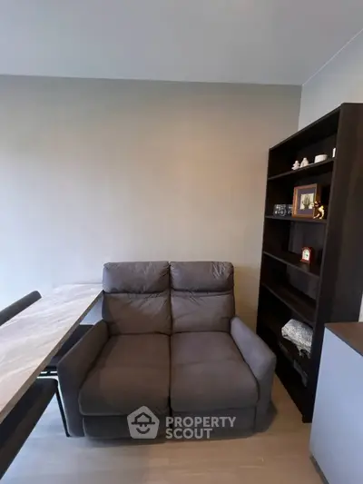 Cozy living room with plush sofa and modern bookshelf, perfect for relaxation and storage.