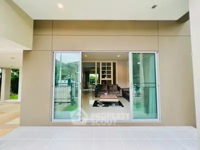 Modern living room with large glass sliding doors and stylish interior design.