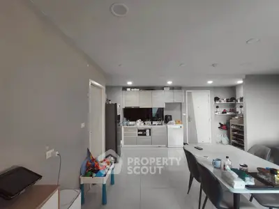 Modern kitchen with sleek cabinetry and dining area in open layout apartment