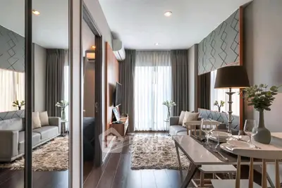 Modern living room with elegant decor and dining area, featuring plush rugs and natural light.