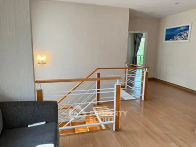 Modern interior with wooden flooring and stylish staircase in a bright living space.