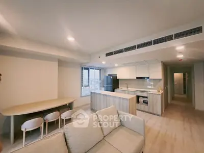 Modern open-plan living room and kitchen with sleek design and natural light
