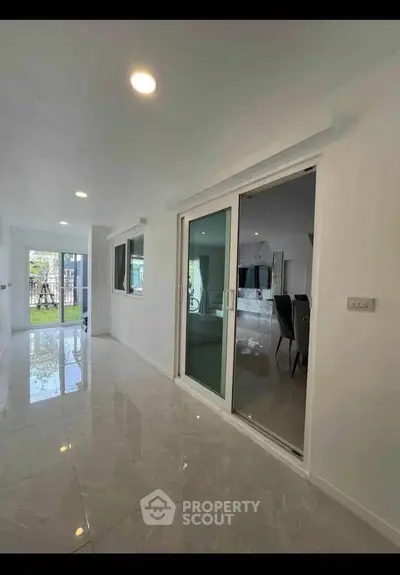 Spacious modern interior with glossy tiles and sliding glass doors, perfect for open living.