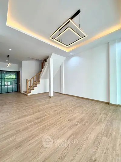 Spacious modern living room with elegant lighting and wooden flooring