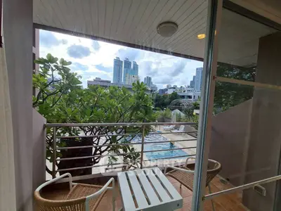 Charming balcony with city skyline view and poolside ambiance, perfect for relaxation.