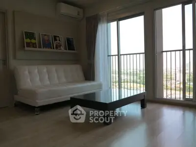 Modern living room with white sofa, large window, and city view.