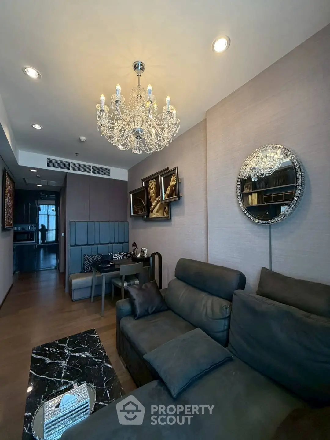 Luxurious living room with elegant chandelier and modern decor in upscale apartment.
