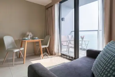 Chic living room with ocean view balcony, modern furniture, and elegant decor.