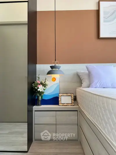 Modern bedroom with stylish decor and cozy lighting, featuring a comfortable bed and elegant nightstand.