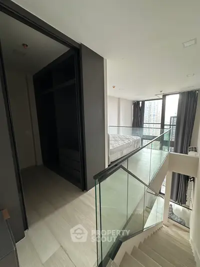 Modern duplex with glass railing and city view from bedroom
