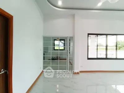 Spacious modern living room with large windows and glossy tile flooring