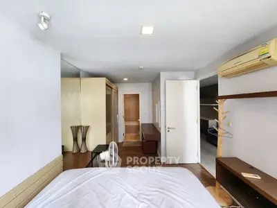 Spacious bedroom with modern decor and air conditioning in a stylish apartment.