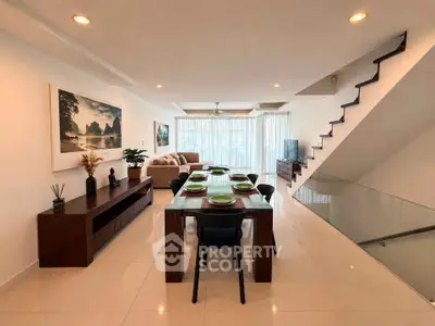 Spacious modern living room with elegant dining area and stylish staircase in a luxury apartment.